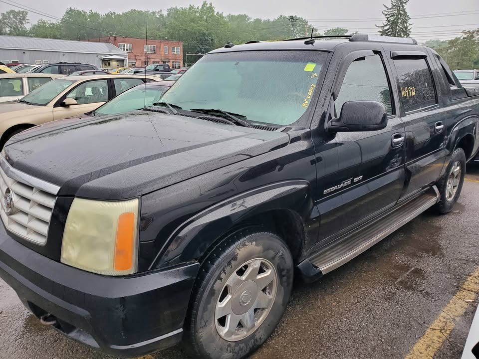 Black Cadillac Escalade EXT pickup in a lot