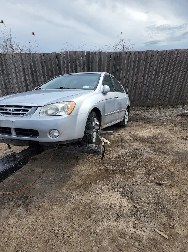 Silver Kia sedan hooked up for towing