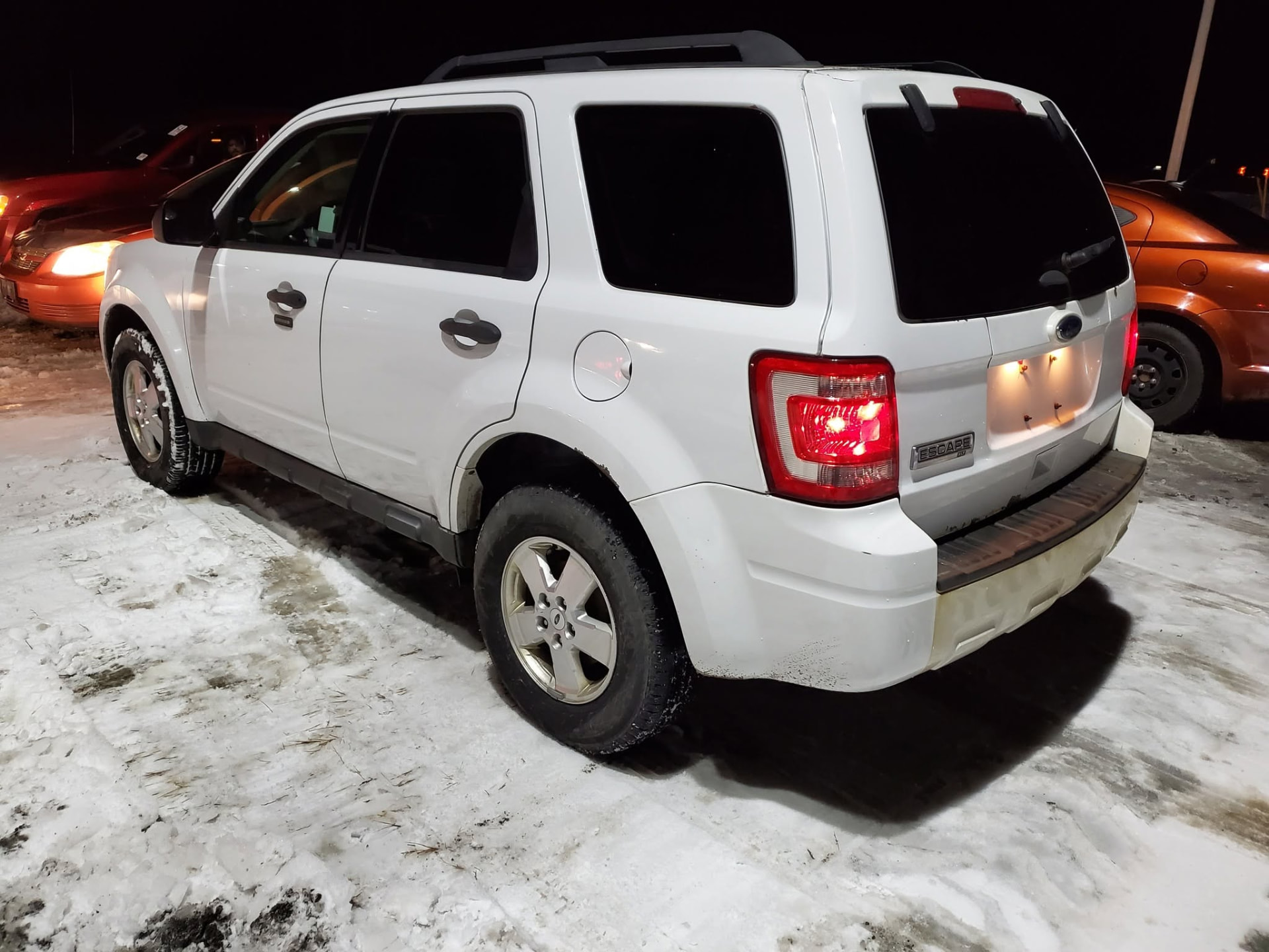 White Ford Escape SUV purchased at night in the snow